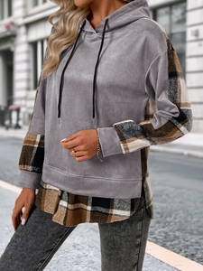 Détail d'un sweat à capuche gris en suédine avec manches et ourlet à motif écossais