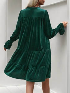 Detail of dark green velvet tiered dress with elastic ruffled cuffs and layered texture