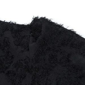 Detailed macro view of black dress fabric featuring a 3D textured tufted pattern texture
