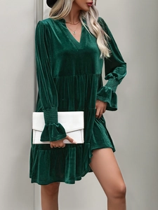 Detail of velvet dress sleeve with elegant ruffles and tiered skirt design