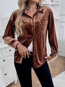 Detailed view of brown velvet shirt texture with collar and front pocket in soft lighting
