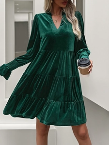 Detailed view of tiered velvet mini dress with smocked sleeves and V-neckline texture