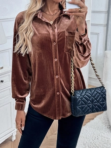 Detail of a brown velvet long sleeve shirt with lapels and a button-down front pocket