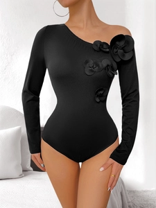 Detail of 3D fabric flowers on a black one-shoulder long sleeve bodysuit for women
