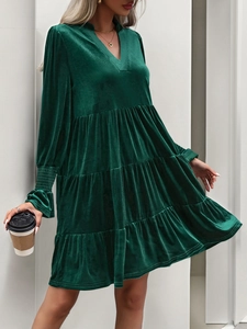 Detail of the V-neckline and rich texture of the green velvet tiered party dress