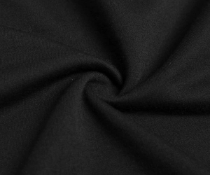 Macro view of black knitted fabric texture showing dense weave and soft matte finish