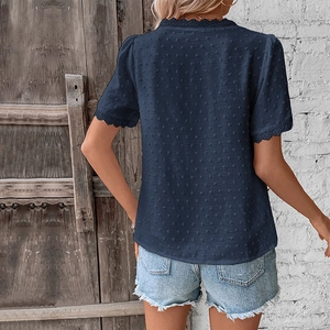 Detail of navy textured top with Swiss dot fabric and delicate lace trim on neckline