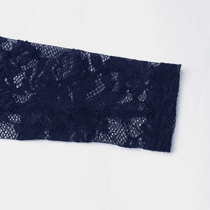 Détail rapproché des motifs de dentelle florale bleu foncé sur la manche du body femme
