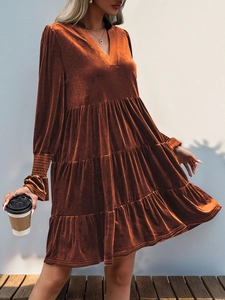 Detail of caramel velvet V-neck dress featuring layered tiered skirt and elastic cuffs