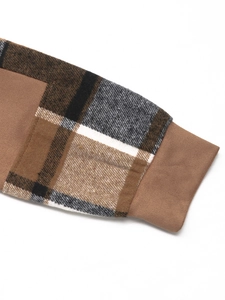 Détail de la manche en patchwork de tartan avec poignet en maille côtelée marron