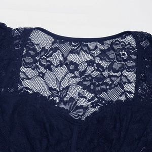 Vue macro du corsage en dentelle bleu foncé avec motifs floraux et texture en maille fine
