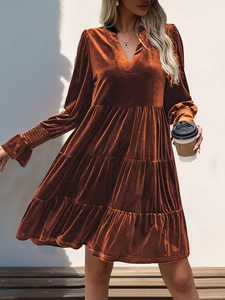 Detail of the elegant V-neck long sleeve velvet tiered dress in rust red color