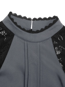 Detail of dark gray high-neck shirt with black lace trim and pleated front panel
