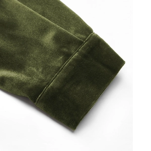 Macro detail of dark green velvet sleeve cuffs with elegant sheen and clean stitching