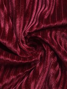 Vue macro de la texture du tissu en velours rayé bordeaux avec un éclat soyeux chic