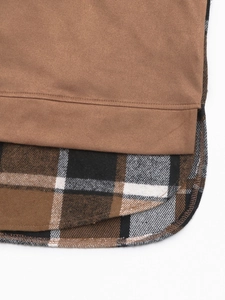 Détail de l'ourlet en faux deux-pièces montrant du daim marron et tissu à carreaux