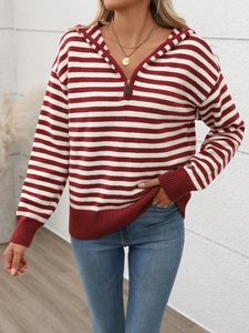 Dettaglio felpa in maglia a righe rosse e bianche con mezza zip e polsini a costine