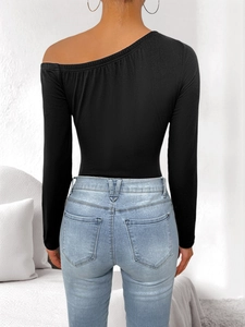 Back view of a black one-shoulder long sleeve bodysuit with light blue slim-fit jeans
