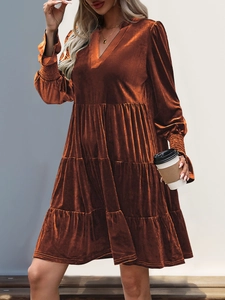 Detail of caramel velvet long sleeve dress with tiered ruffle hem and V-neckline