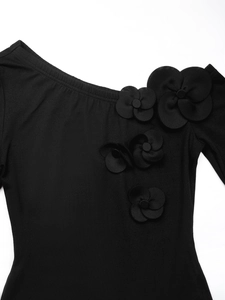 Close-up of 3D fabric flowers on black one-shoulder bodysuit with knitted texture