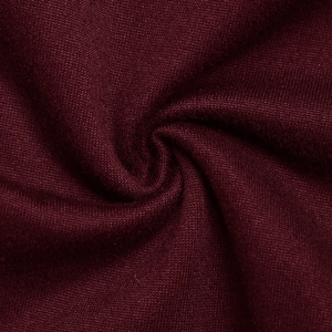 Vue macro d'un tissu tricoté bordeaux montrant des plis souples et une texture de qualité