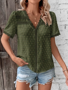 Detail of olive green Swiss dot fabric with delicate lace crochet trim on the V-neckline