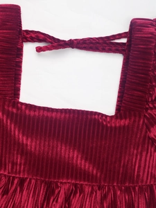 Détail de la robe en velours bordeaux avec encolure carrée et décoration de nœud texturé