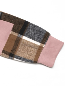 Détail d'une manche à carreaux avec couture de poignet rose sur un sweat à capuche
