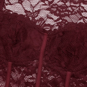 Gros plan sur la dentelle florale bordeaux et les baleines de maintien du bustier