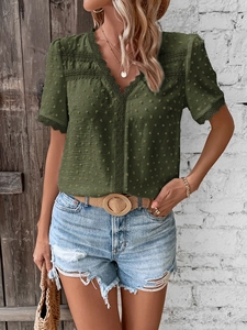 Detail view of dark green V-neck top with dot jacquard texture and lace trim edges