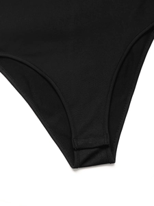 Detailed close-up of the overlapping snap button closure on a black bodysuit crotch