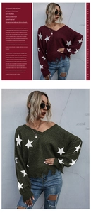 Detail of V-neck knitted sweater with star pattern and distressed fringe hem finish