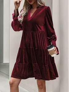 Macro detail of wine red velvet dress showing layered ruffles and textured fabric