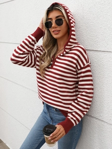 Dettaglio maglione a righe rosse e bianche con mezza zip, cappuccio e polsini a coste