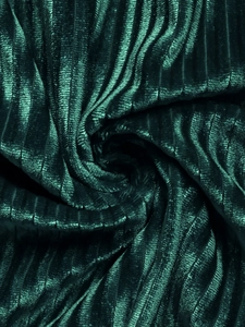 Macro détaillée d'un tissu velours plissé vert foncé avec reflet métallique et texture douce