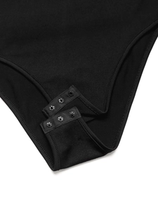 Detailed macro view of black bodysuit bottom with functional three-button snap closures