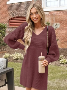 Detail of burgundy waffle knit dress with v-neckline and lantern sleeves in outdoor setting