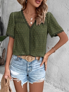 Detail of olive green V-neck shirt with textured dots and intricate lace trim detailing