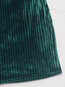 Vue macro de la texture du tissu plissé en velours vert foncé aux plis verticaux