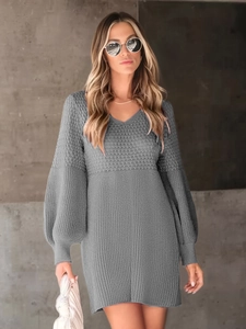 Detail shot of grey knitted V-neck dress with puff sleeves and textured fabric