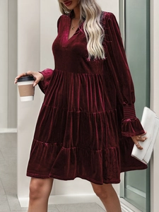 Close-up of velvet texture and layered ruffle hem on burgundy long sleeve party dress