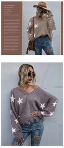 Detail showing distressed hem and star pattern on V-neck knitted sweater