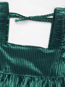 Détail de robe en velours vert émeraude avec col carré, tissu texturé et nœud au dos