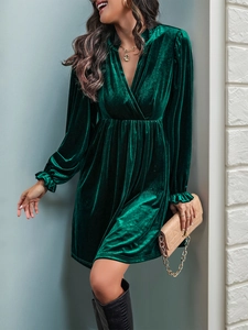 Détail d'une robe en velours vert foncé avec col en V et texture vintage à taille haute