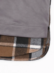 Détail de l'ourlet arrondi avec faux suède gris et couture en flanelle à carreaux