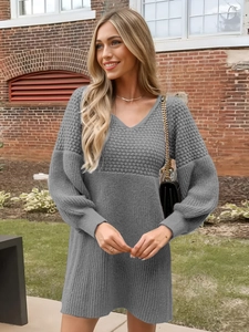 Detail of grey V-neck knit mini dress with puff sleeves and thick ribbed texture