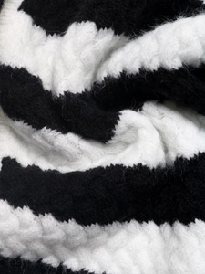 Macro view of plush black and white striped knit fabric with soft mohair texture