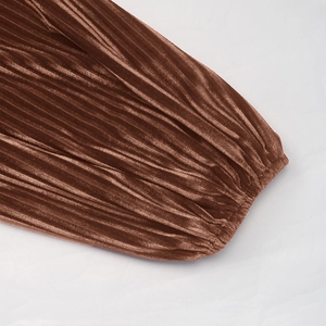 Détail macro d'une robe en velours marron avec texture plissée et fini brillant