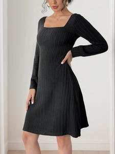 Détail de la robe en tricot trapèze noire avec encolure carrée et texture côtelée