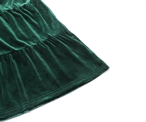 Detail of dark green velvet dress featuring elegant layered pleats and soft texture